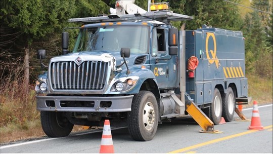 Un camion-grue accroche des fils sur la route 153 à Lac-aux-Sables